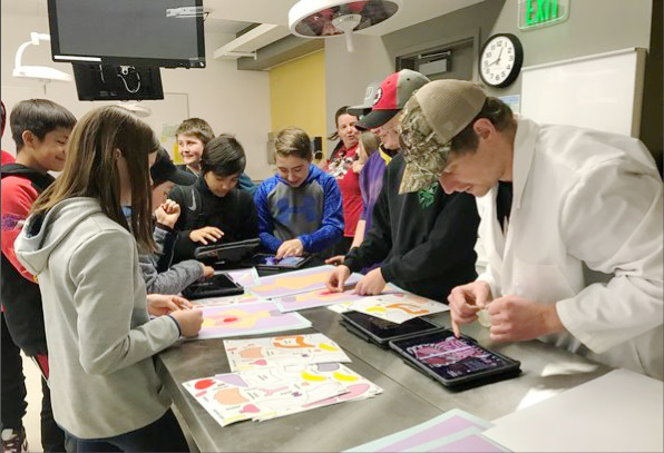 A group of middle school students using iPad during their medical mentorship program.